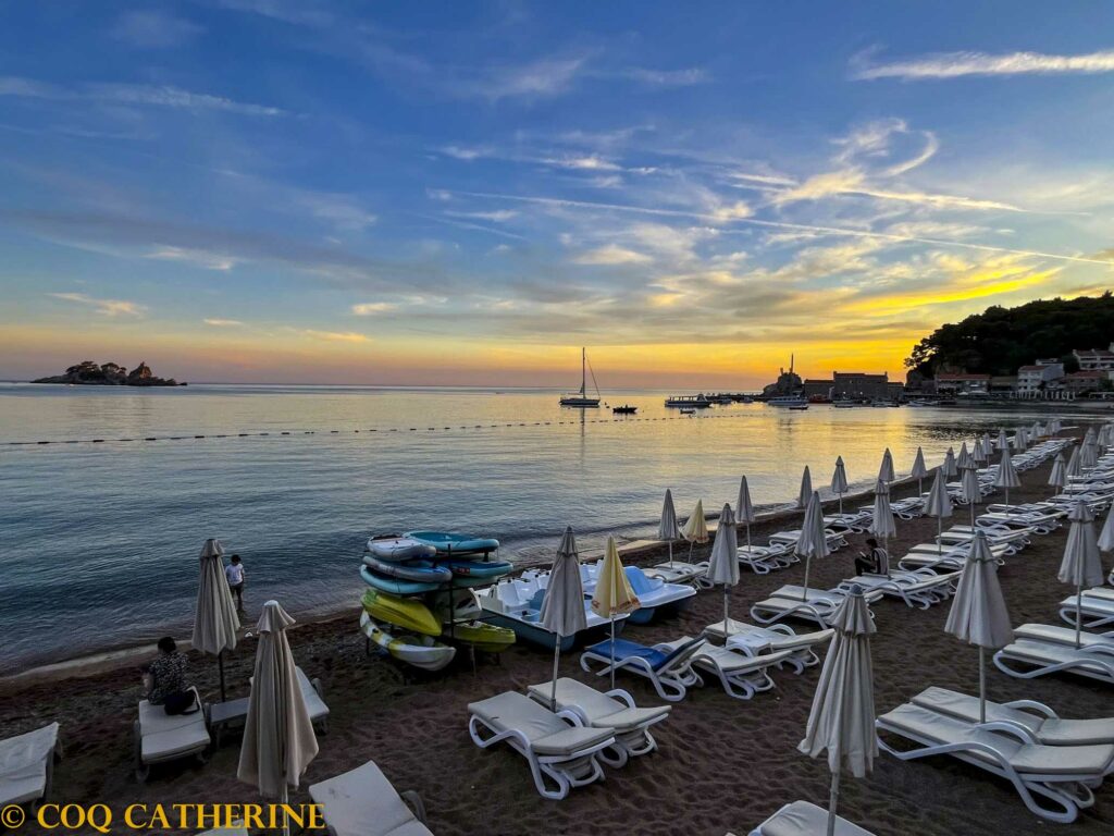 Le port et la plage et les parasols de Petrovac avec les iles au coucher du soleil