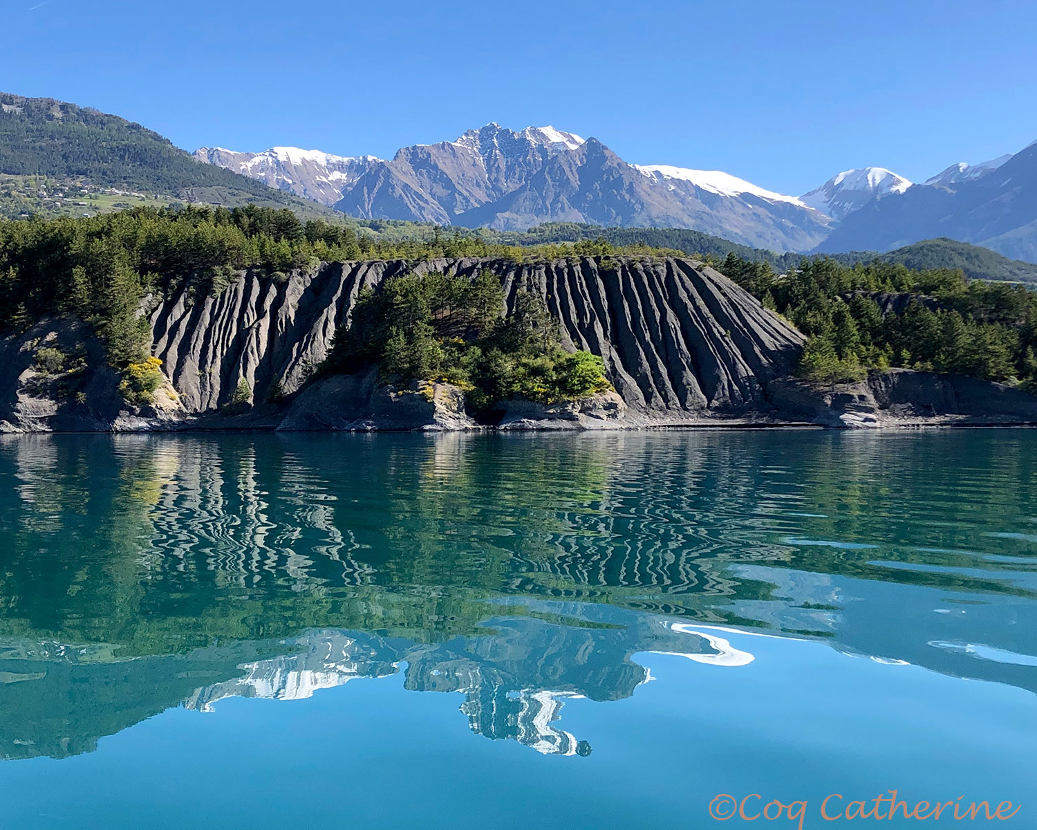 le reflet des montagnes enneigées sur le lac de Serre-Ponçon