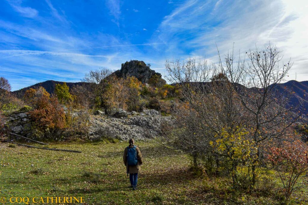 Une personne marche dans un champ sous le Rocher de Gassendi