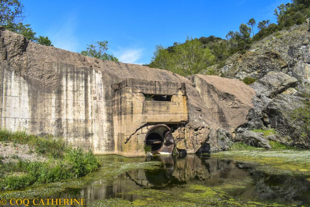 le déversoir du barrage de Malpasset se reflète dans l’eau