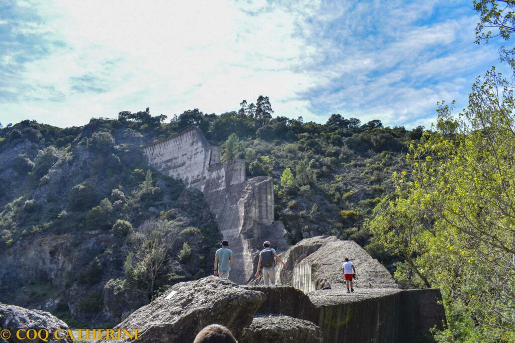 des personnes marchent sur les ruines du mur du barrage de Malpasset 