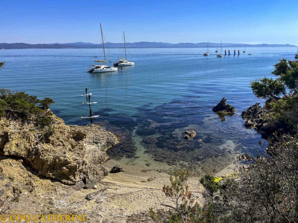 Des catamarans, des bateaux à voiles et des paddles dans la mer, autour de la presqu’ile de Giens