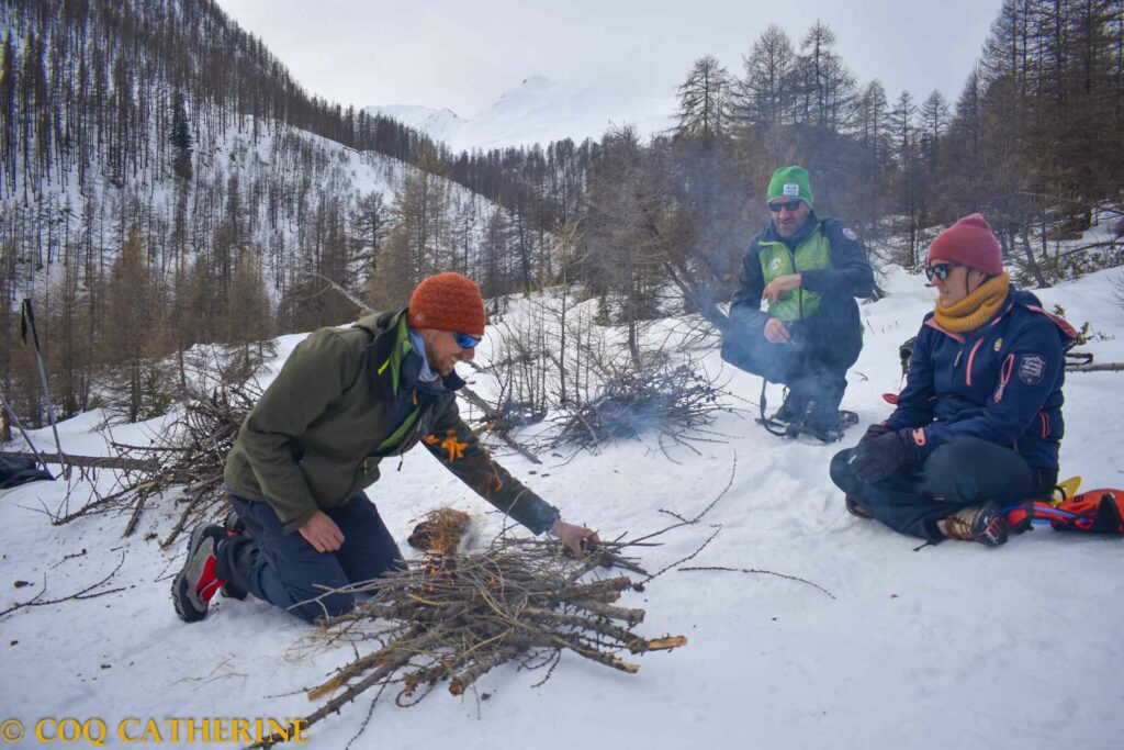 le guideet le groupe préparent le feu avec du bois dans la neige