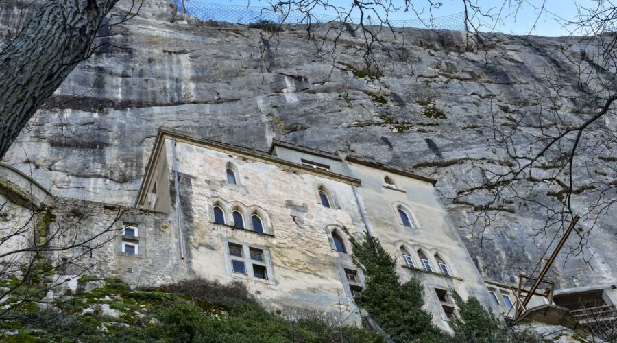 Les murs des bâtiments du monastère de la Sainte Baume dans les falaises et entre les arbres