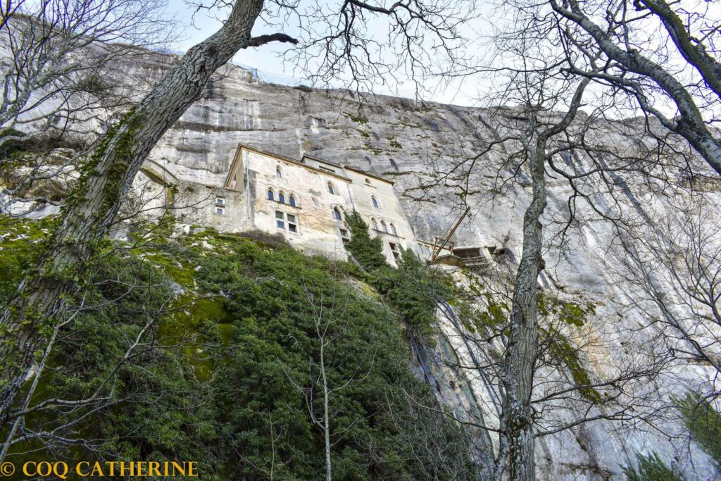 Les murs des bâtiments du monastère de la Sainte Baume dans les falaises et entre les arbres