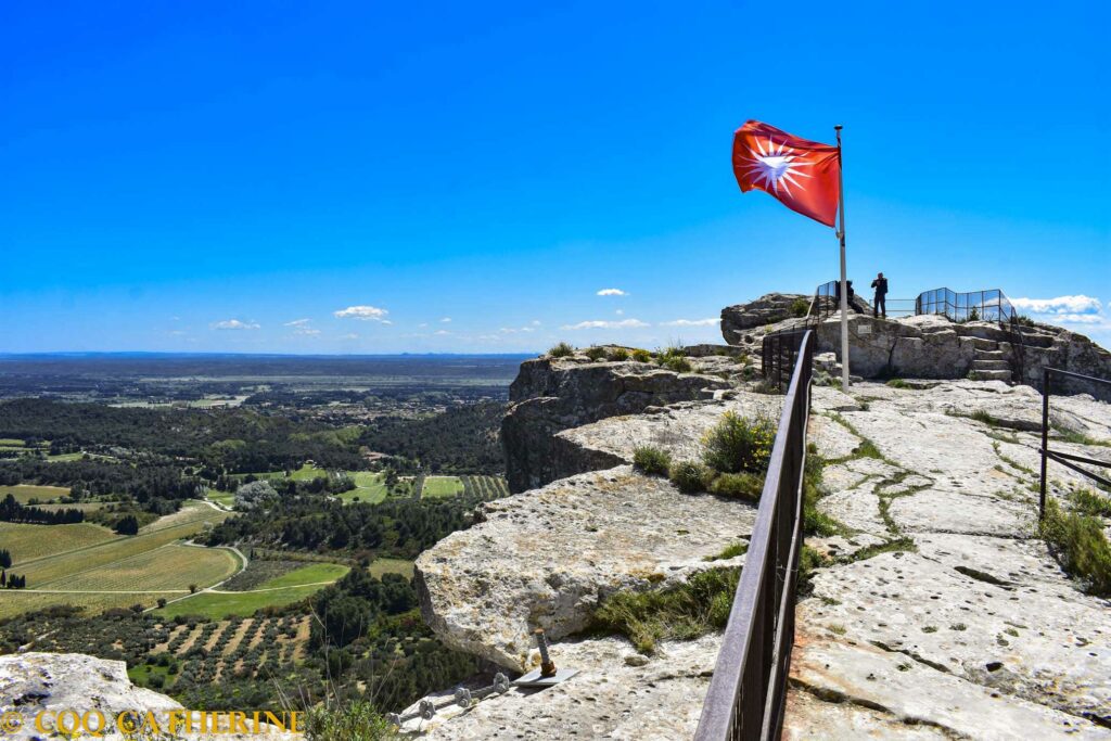 sur le sommet des falaises avec le drapeaux rouge des Baux de Provence avec le panorama sur la Camargue