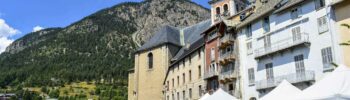 Les façades de Briançon avec une terrasse de café et les murs d’enceinte et les clochers de la collégiale