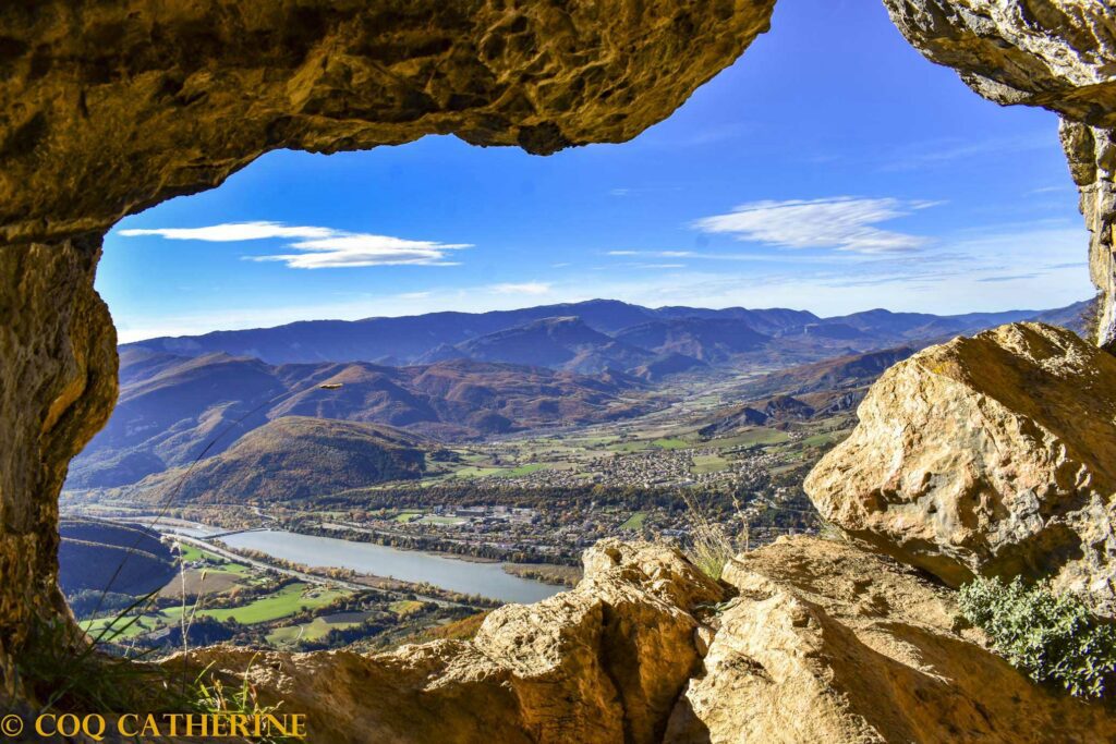 le trou de l’Argent dans la falaise de la Baume de Sisteron avec un panorama sur la Durance