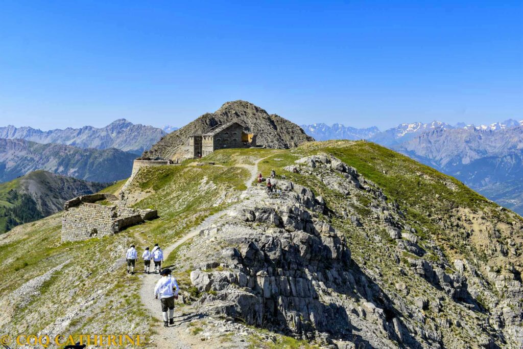 des personnes marchent vers le vieux fort du XIXe siècle du Janus avec le panorama sur les montagnes