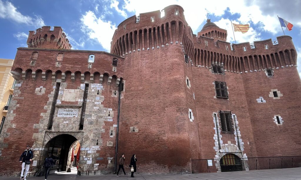 porte du Castillet à Perpignan en brique rouge et avec des tours et des machicoulis