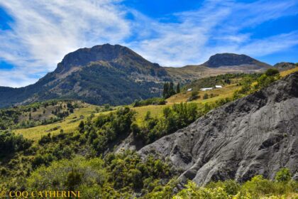 Les sommets des Cloches de Barles avec les champs et les toits du village de Forest