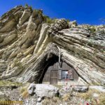 La cabane de Boules en bois qui est dans la falaise avec une cheminée