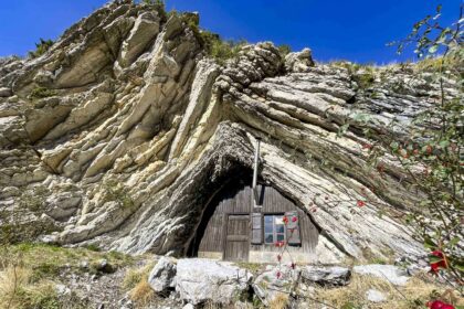 La cabane de Boules en bois qui est dans la falaise avec une cheminée