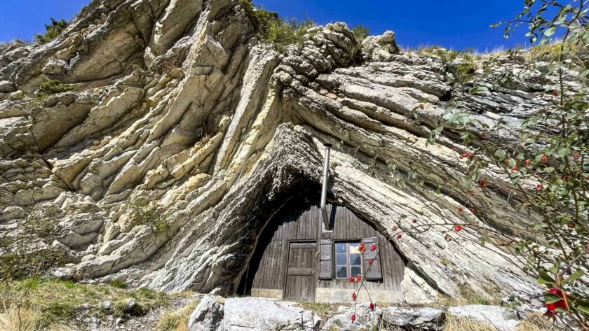 La cabane de Boules en bois qui est dans la falaise avec une cheminée