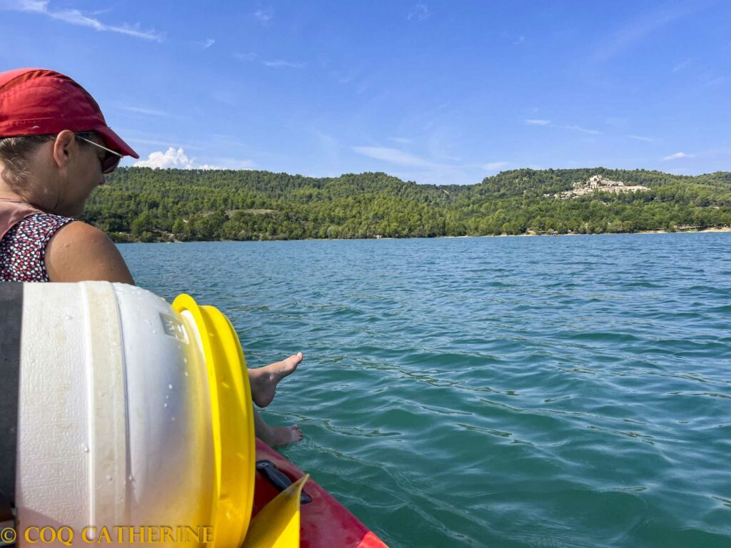 une femme dans le canoë kayak sur le lac de Montpezat avec le bidon et la village