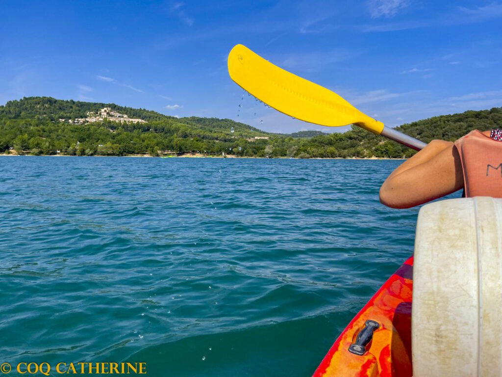 dans le canoë kayak sur le lac de Montpezat avec la rame et le village