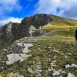 Panorama sur les falaises des Monges avec des randonneurs qui marchent dans l’herbe