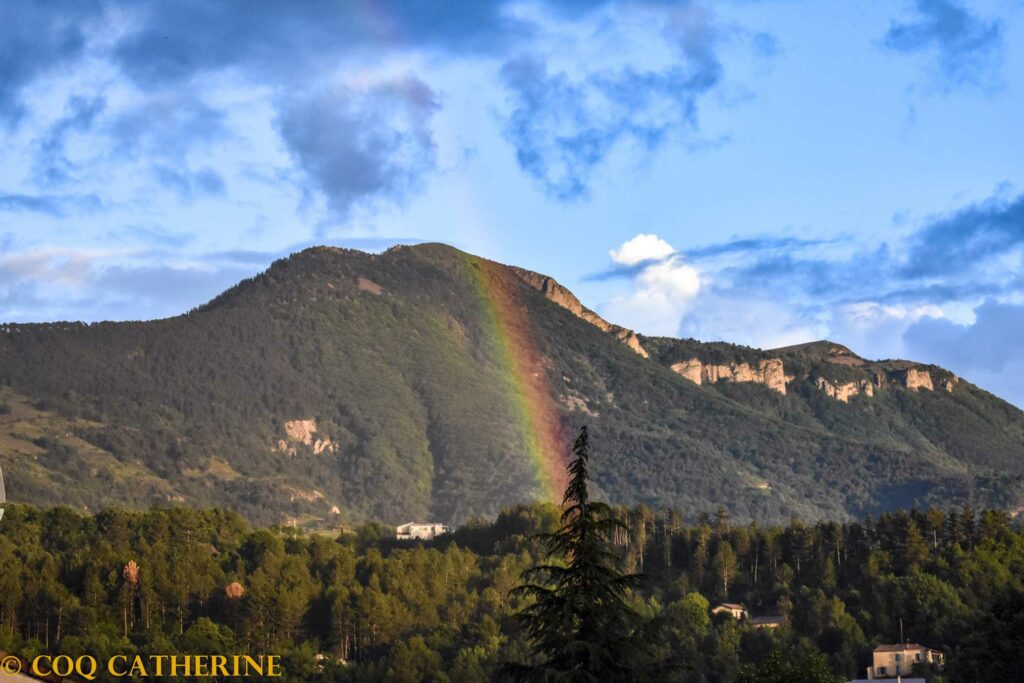 le sommet du Cousson dominant Digne les Bains avec un arc en ciel