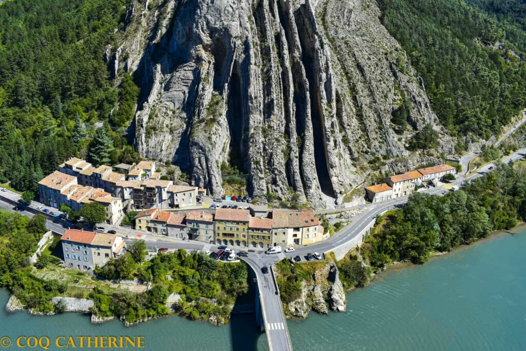 Panorama sur la Baume de Sisteron avec les falaises verticales, les maisons et le pont sur la Durance