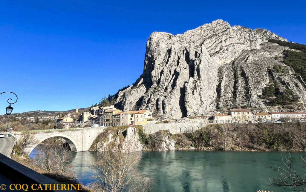 Panorama sur la Baume de Sisteron avec les falaises verticales, les maisons et le pont sur la Durance