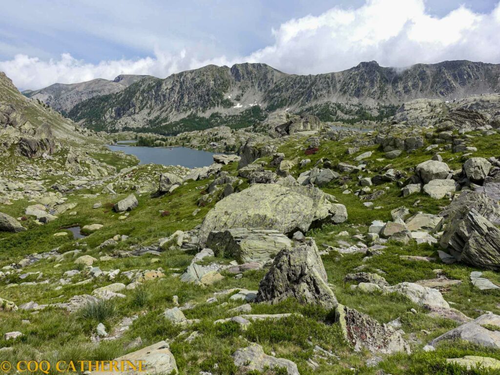 Panorama sur le lac long dans la Vallée des Merveilles avec des blocs de rochers