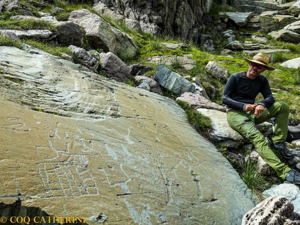 Un guide présente les gravures de la Vallées des Merveilles dans le Mercantour avec un dalle gravée