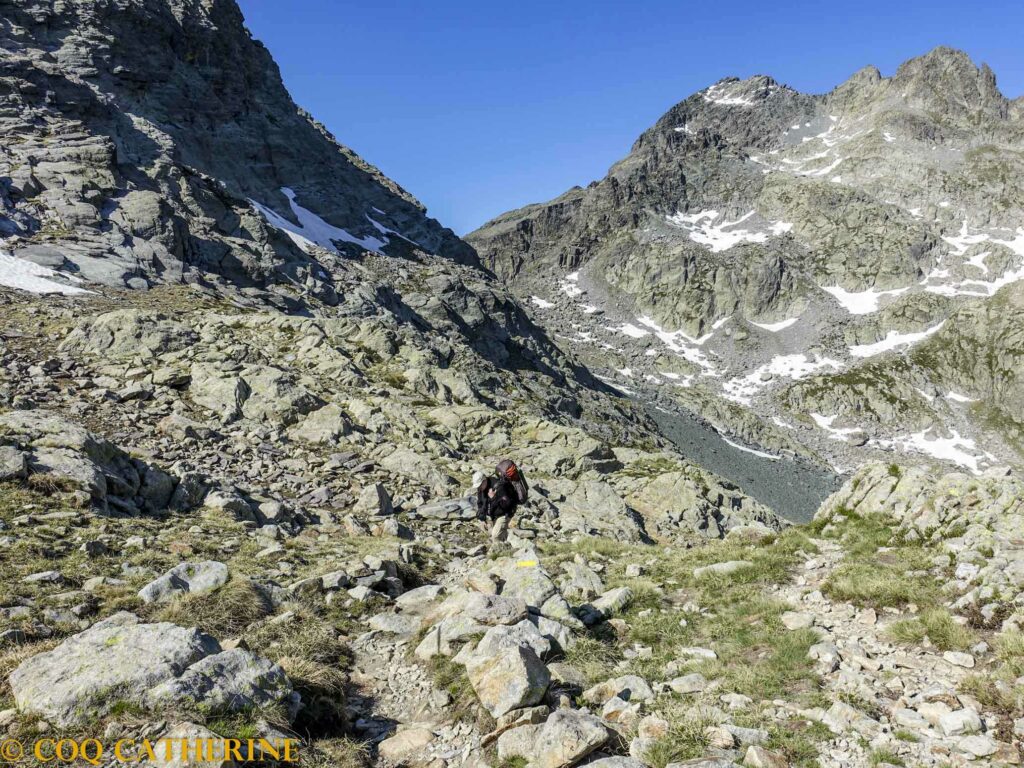 Un homme marche sur le sentier qui monte à la Baisse de Fontanalba sur le chemin de la Vallée des Merveilles