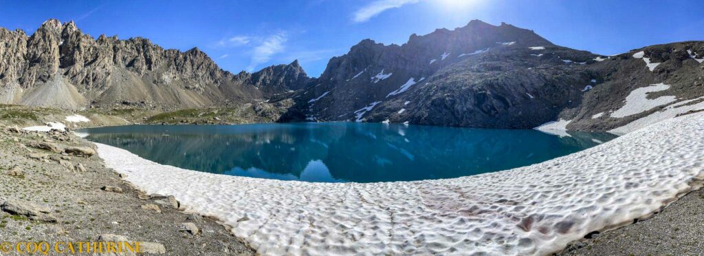 Le lac des neuf couleurs avec de la neige et les sommets rocheux