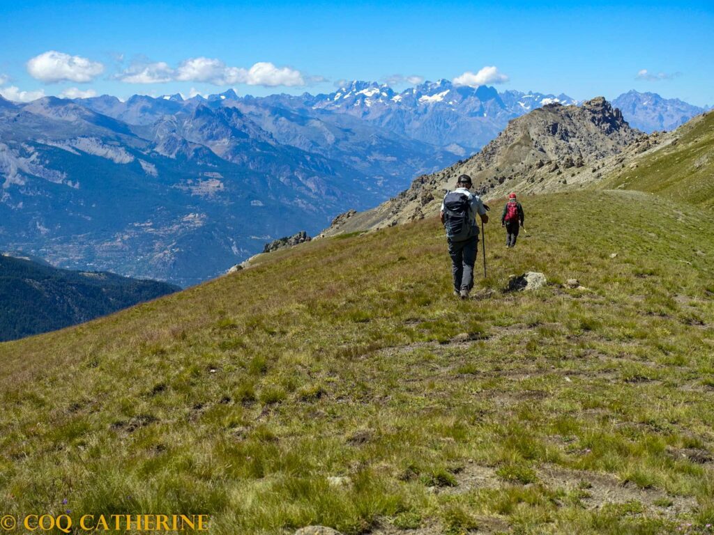 Sur le sentier de randonnée de la Mortice avec un panorama sur les glaciers des Ecrins avec des randonneurs
