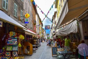 Une rue de Barcelonnette en Ubaye avec des façades colorées et des drapeaux