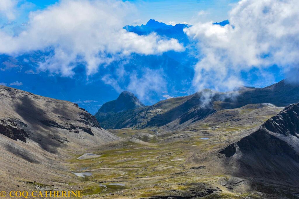 Panorama sur le vallon de la Selle et les lacs avec le Mont Viso et les nuages, depuis le sommet de la Tête de Vautisse