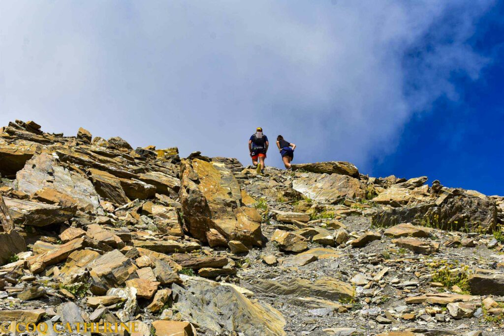Deux randonneurs dans les pierriers du chemin de randonnée de la Tête de Vautisse