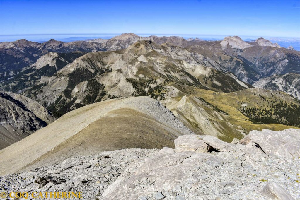 Sur le chemin de descente du Mont Cimet dans les pierriers avec le panorama sur l’Estrop et la Grande Séolane