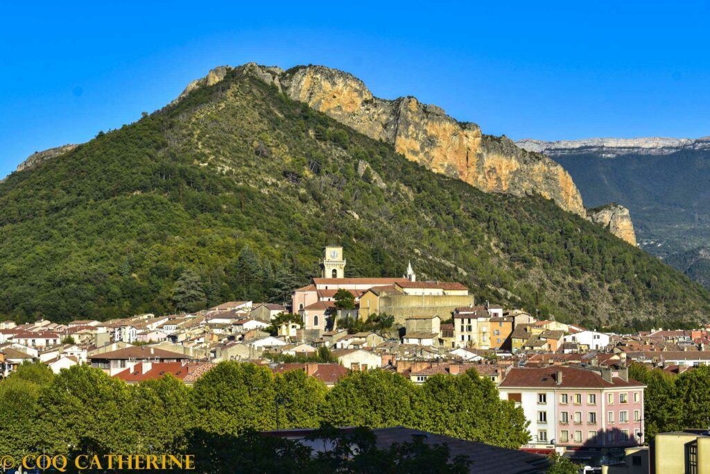 Panorama sur la ville de Digne les Bains dominée par le clocher et la falaise de la via ferrata du Rocher de neuf heures