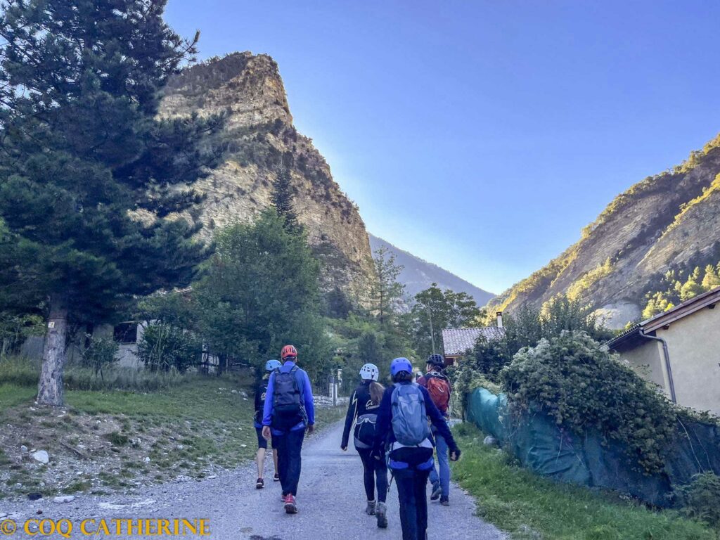 le groupe sur la marche d’approche avec la falaise de la via ferrata de Prads Haute Bléone
