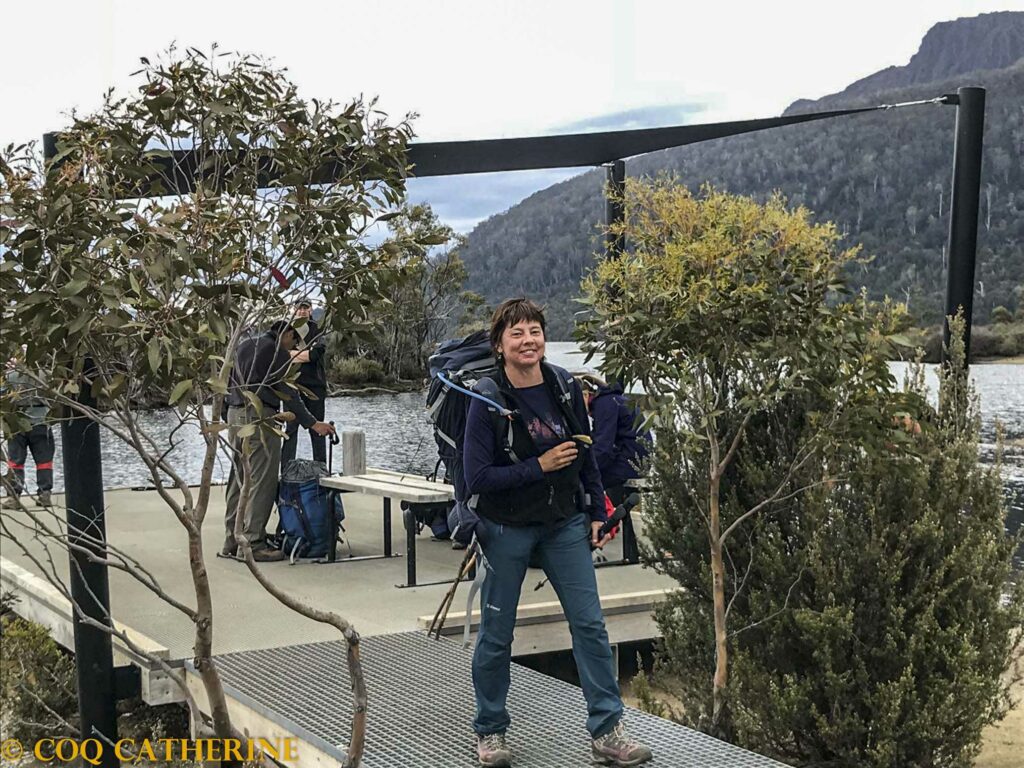 Kat sort d’un bateau entre les arbres et portant un sac à dos