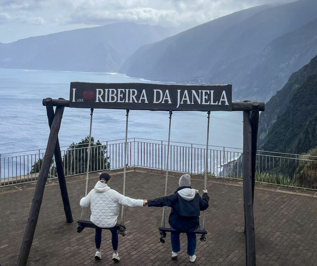 deux personnes sur les balançoires du miradouros de Ribeira de Janela avec la vue sur la mer et les montagnes à Madère