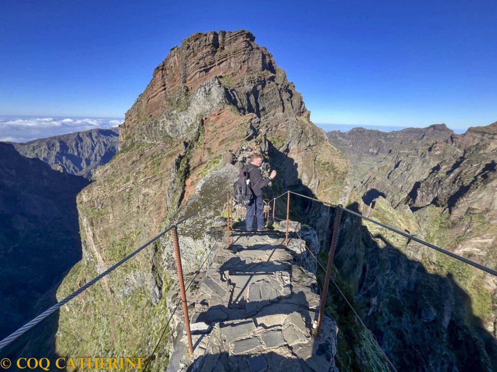Un homme sur un chemin aérien avec des marches sur les sommets de Madère en randonnée