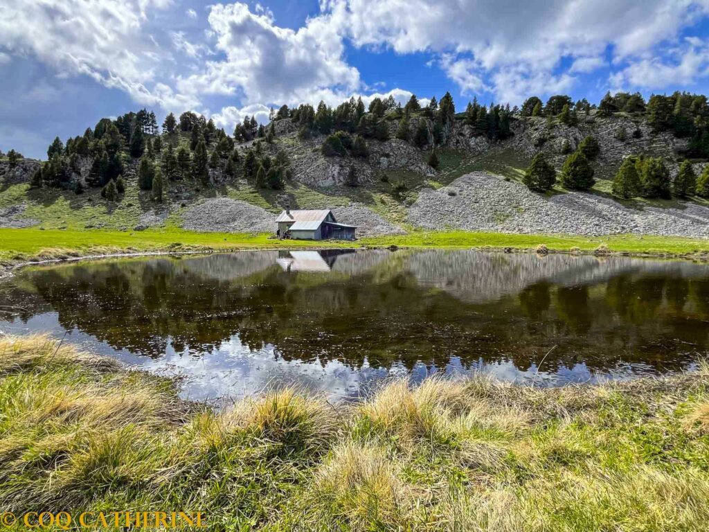 la bergerie des Chamailloux avec son reflet sur le lac avec les arbres et les nuages