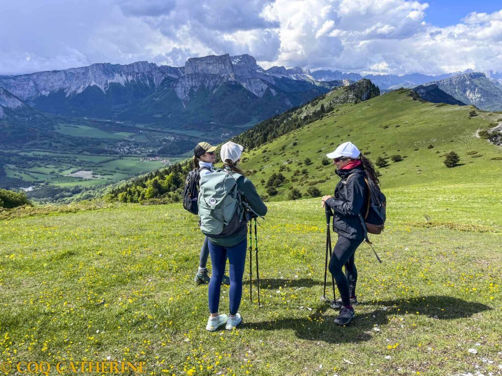 3 randonneuses avec leur sac à dos au sommet du Platary avec le panorama sur le Mont Aiguille et le Vercors