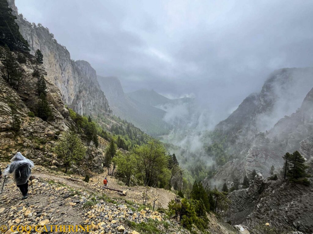descente du pas de l’aiguille dans les nuages avec des randonneurs sur le sentier