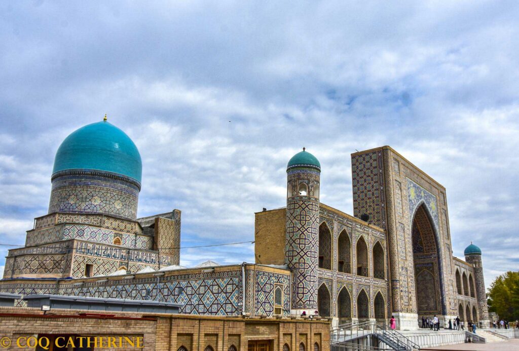 La médersa Tilla-Kari du Registan à Samarkand avec un portail monumentale et décors avec des tigres, un dôme bleu côtelé et des minarets